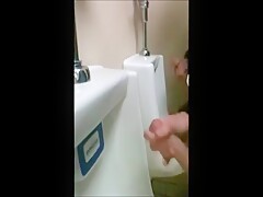 two slim dicks getting wanked at the urinals